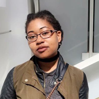 Portrait of Numi in front of an opaque white glass wall at the DIA