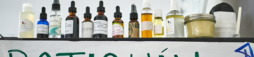 A table lined with natural medicines in bottles of various sizes and shapes