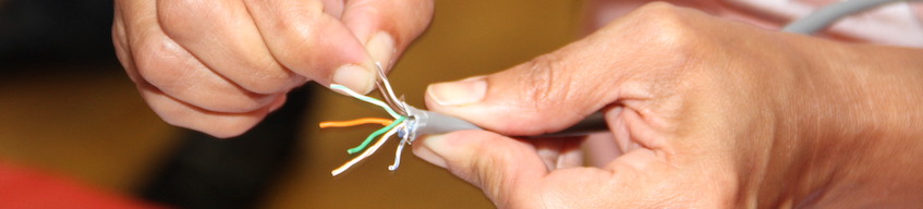 Hands holding a wire that is cut at the end to show its parts