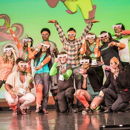 A group of people wearing paper glasses and doing funny poses for the camera