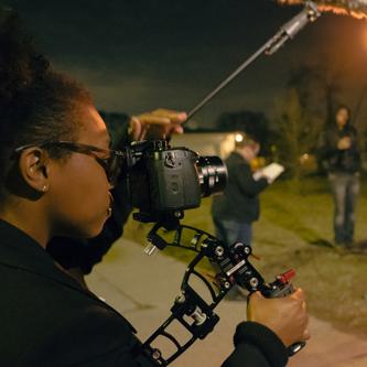 person outside in the dark working with a camera