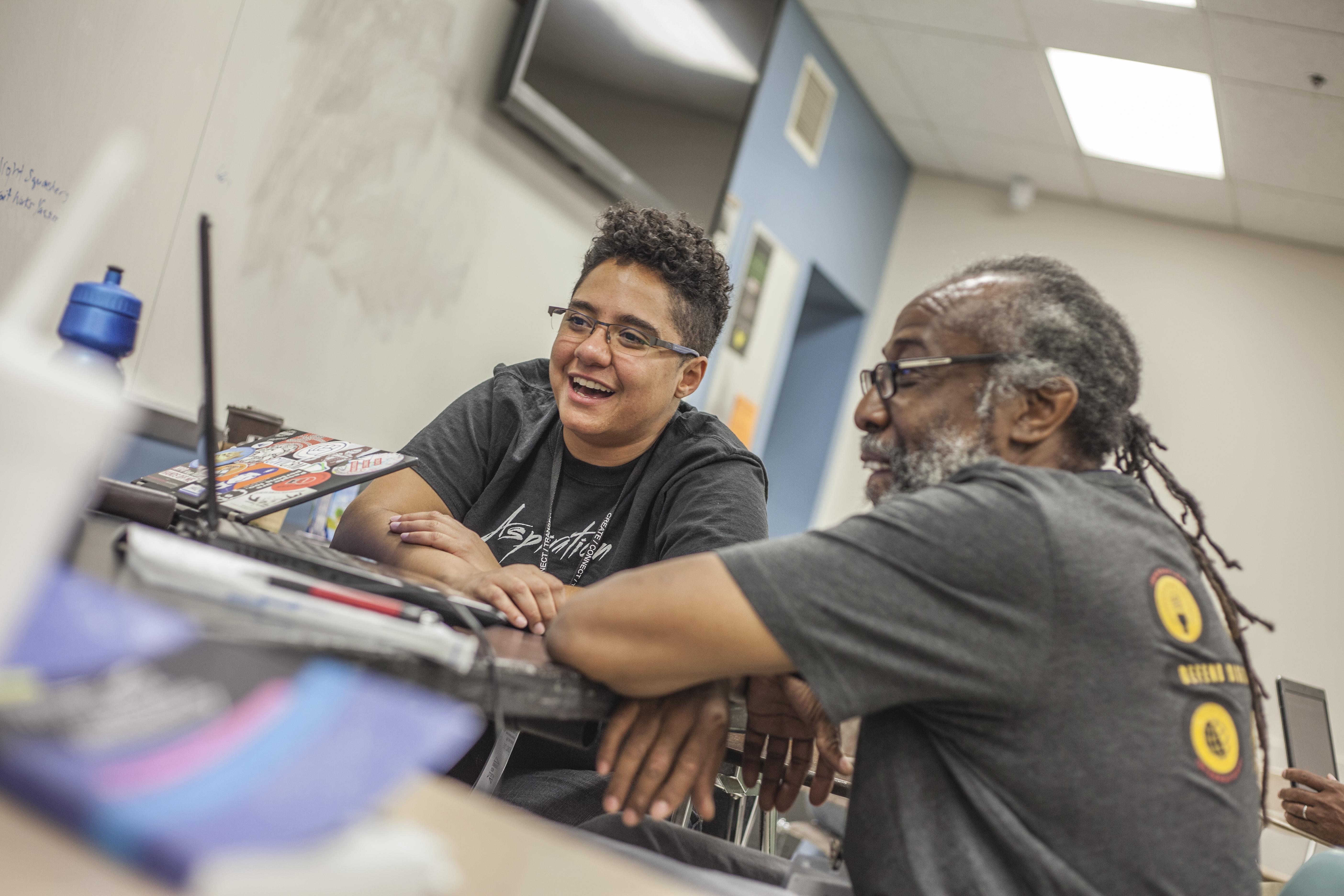 elder and teen using a MAC laptop together