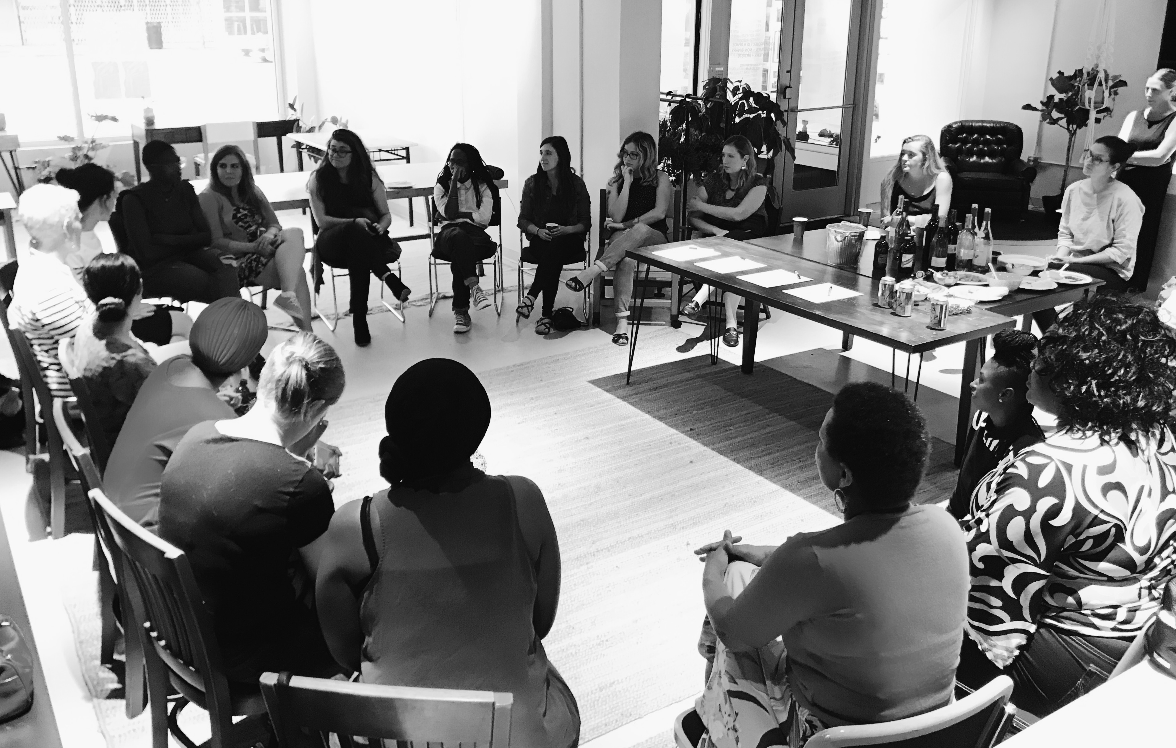 black and white photo of womxn sitting in a circle